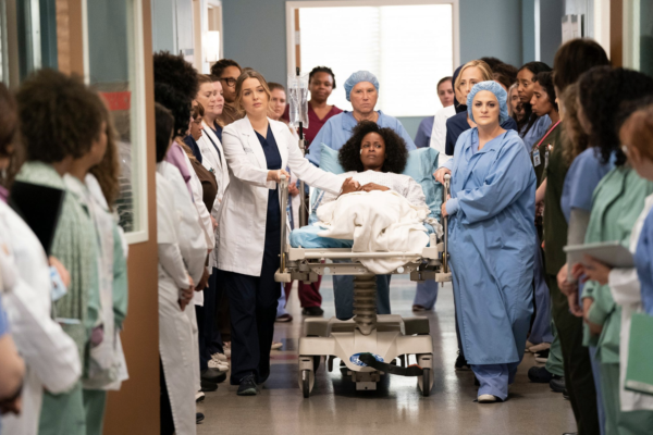 Grey's Anatomy nurses line the halls for a patient.